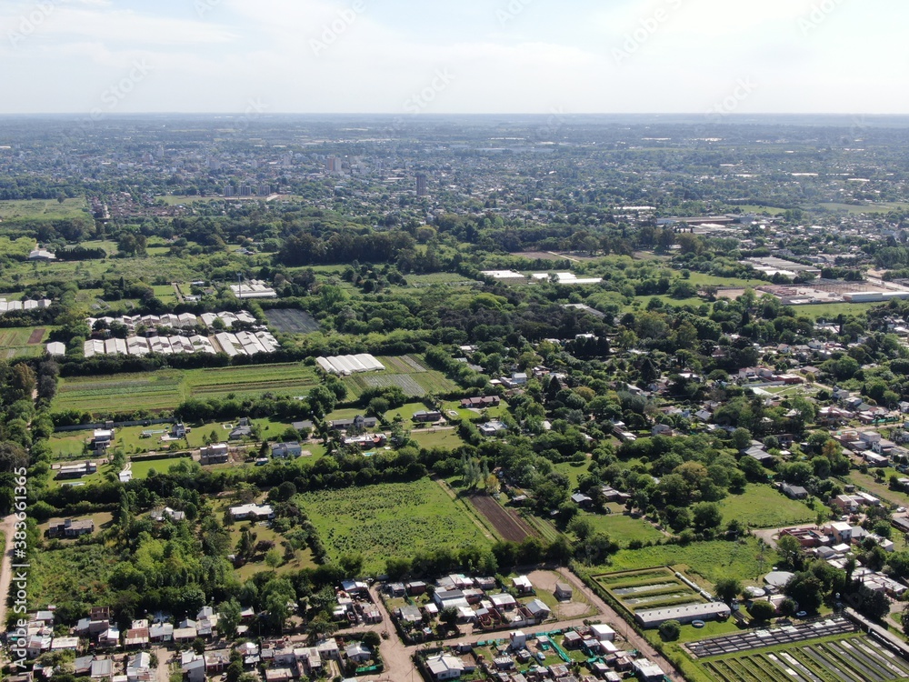 Vista aérea de una ciudad de tamaño mediano , con edificios bajos, alguna edificación y muchos árboles distribuidos en las aceras. 