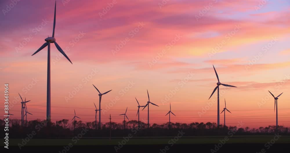 Neusiedl, Austria - November 22 2017: Windmills generating green energy by sunset at Neusiedl Weiden wind park in Austria. Neusiedl, Austria - November 22 2017: Windmills generating green energy by sunset at Neusiedl Weiden wind park in Austria.