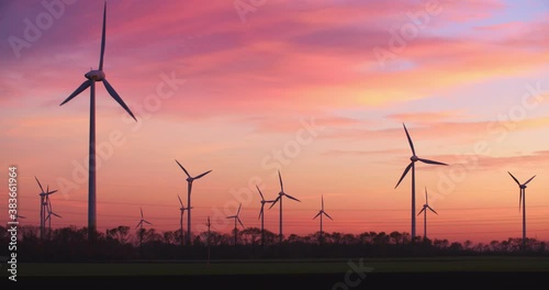 Neusiedl, Austria - November 22 2017: Windmills generating green energy by sunset at Neusiedl Weiden wind park in Austria.