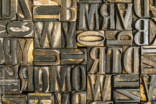 Old wooden letterpress used in a printing press to create reliefs by impressing them against sheets of paper after covering them with ink. Jumbled antique letters. Alphabet background. photo