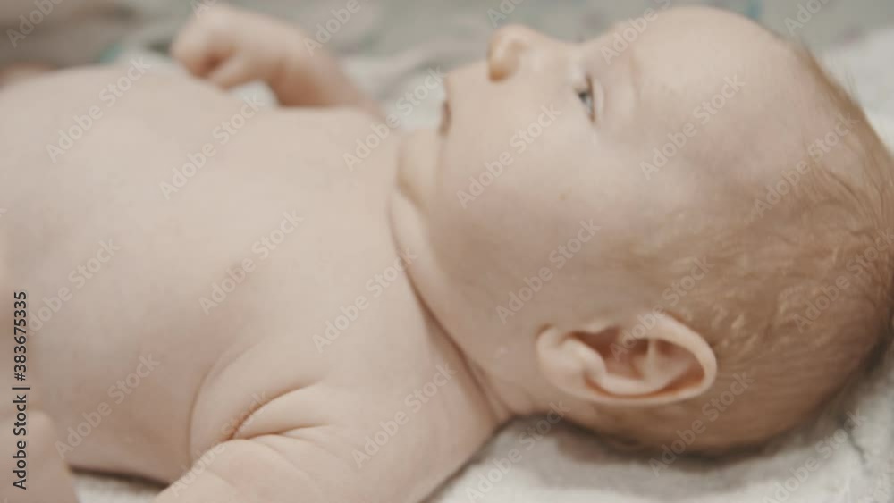 A little cute baby with blue eyes lying in bed before sleep A little cute baby with blue eyes lying in bed before sleep