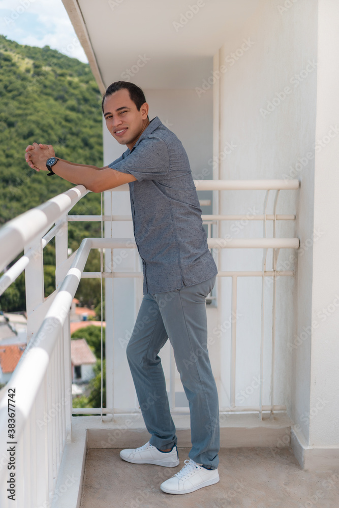 Elegant man standing on the balcony smiling