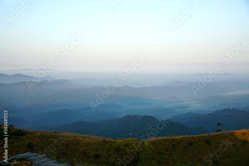 mountain view in morning fog with blue sky