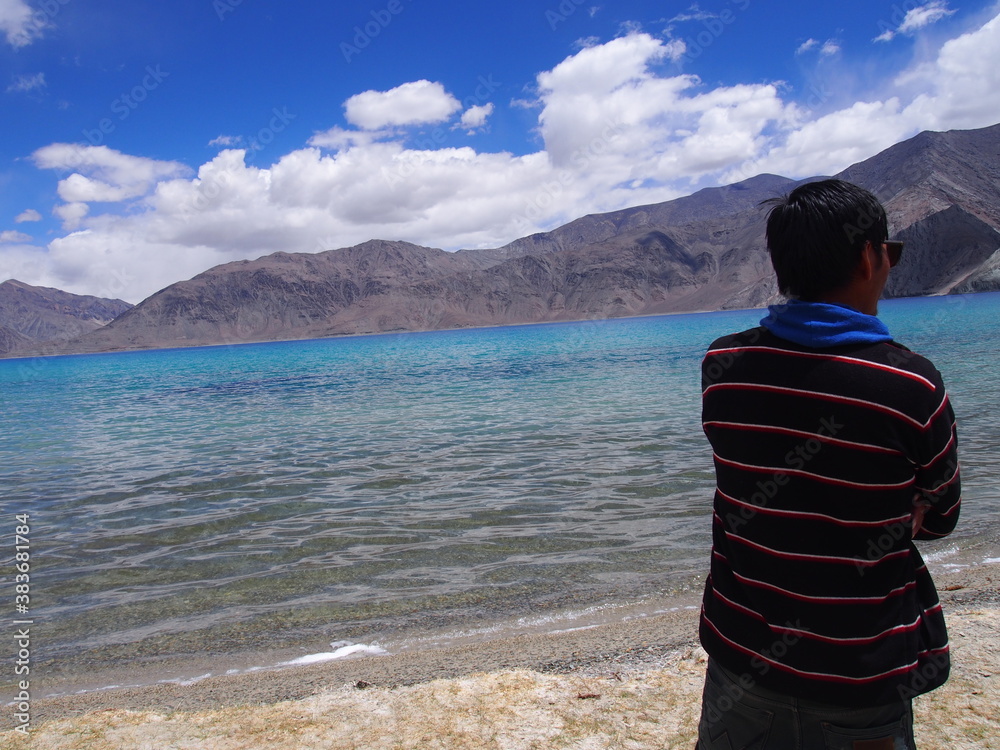 A man looking out at a beautiful lake, Pangong tso (Lake), Durbuk, Leh, Ladakh, Jammu and Kashmir, India
