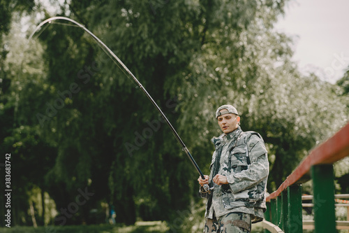 A man fishing on a lake. Guy in a uniform.
