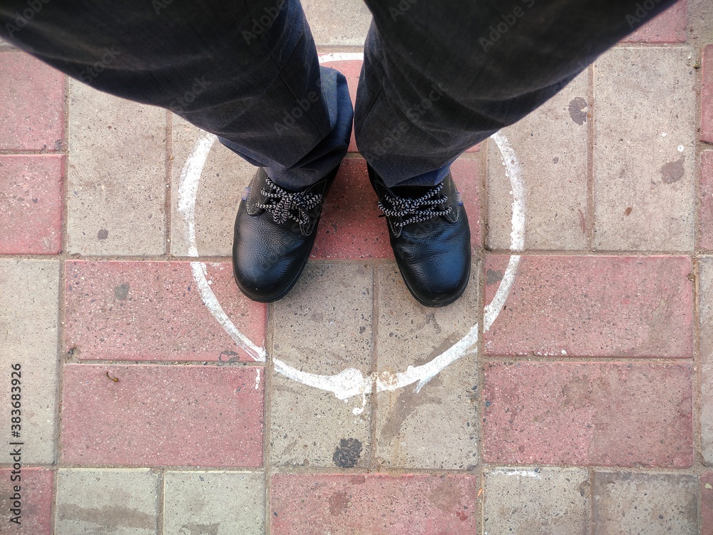 circle on ground for standing in queue , Man feet top view in circle circle on ground for standing in queue , Man feet top view in circle