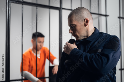 Foto A prison guard in full ammunition communicates with his partner on the radio