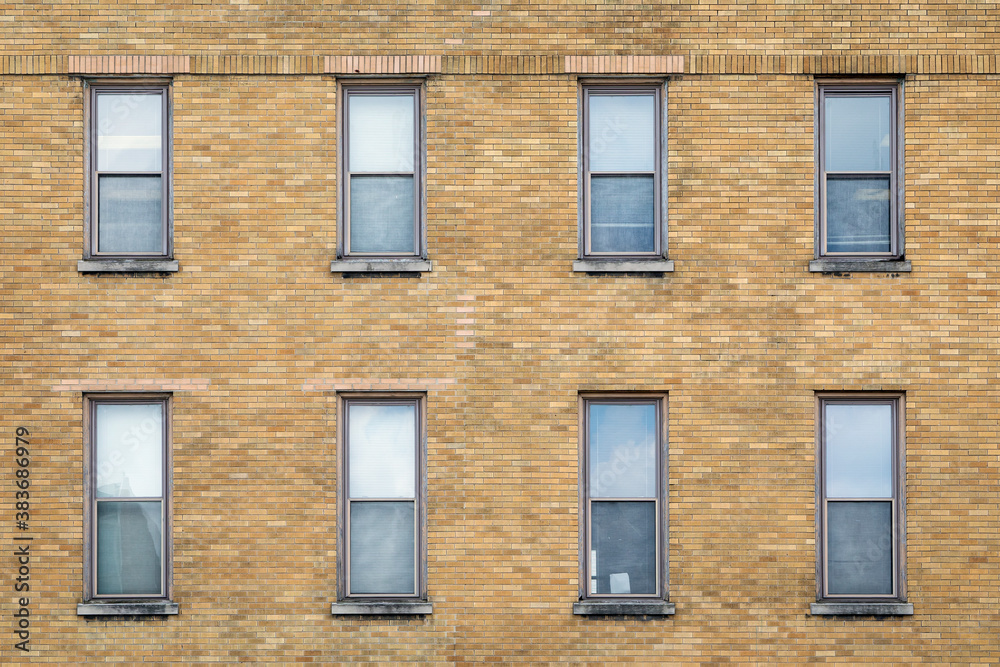 Exterior Wall of a Brown Brick Building with Eight Windows