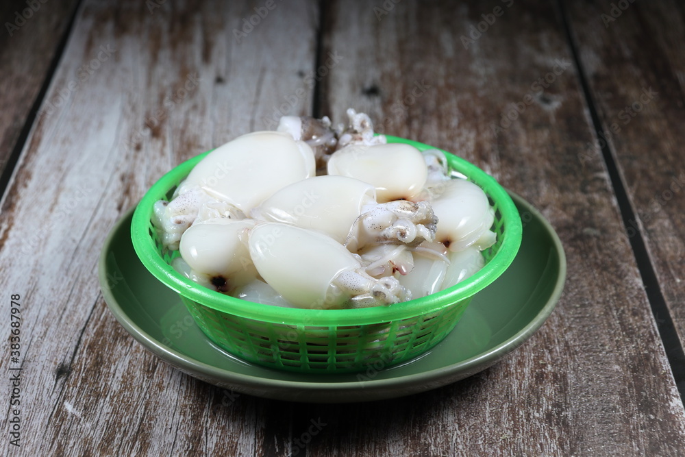 Pile of fresh and organic cuttlefish or squid in the plastic basket. Famous seafood ingredients in Asia restaurant. Pile of fresh and organic cuttlefish or squid in the plastic basket. Famous seafood ingredients in Asia restaurant.