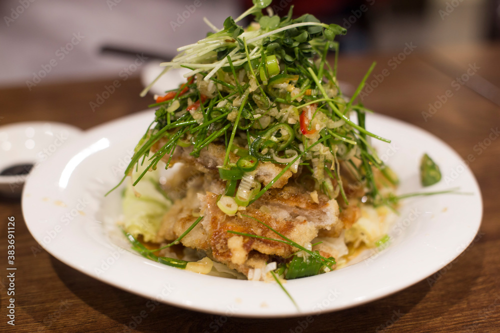 Fried chicken with hot and sour soy sauce topped with chives and green pepper. Fried chicken with hot and sour soy sauce topped with chives and green pepper.