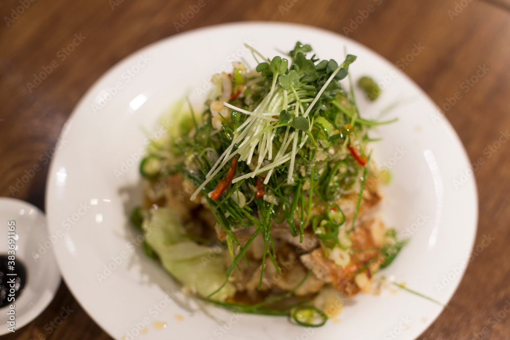 Fried chicken with hot and sour soy sauce topped with chives and green pepper. Fried chicken with hot and sour soy sauce topped with chives and green pepper.