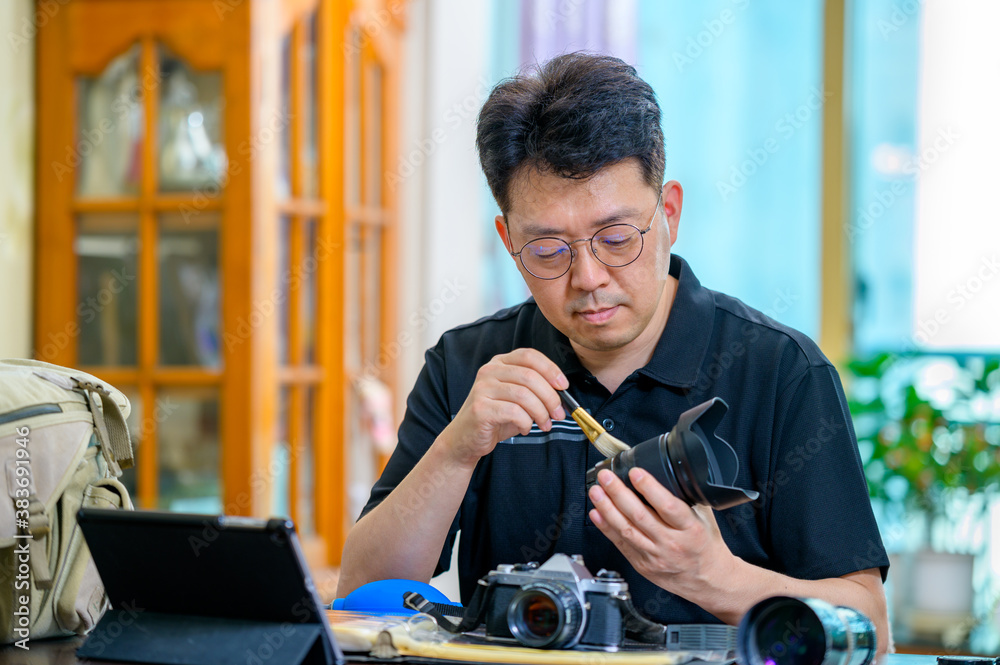A middle-aged Asian man whose hobby is 35mm/135mm film SLR camera. A middle-aged Asian man whose hobby is 35mm/135mm film SLR camera.