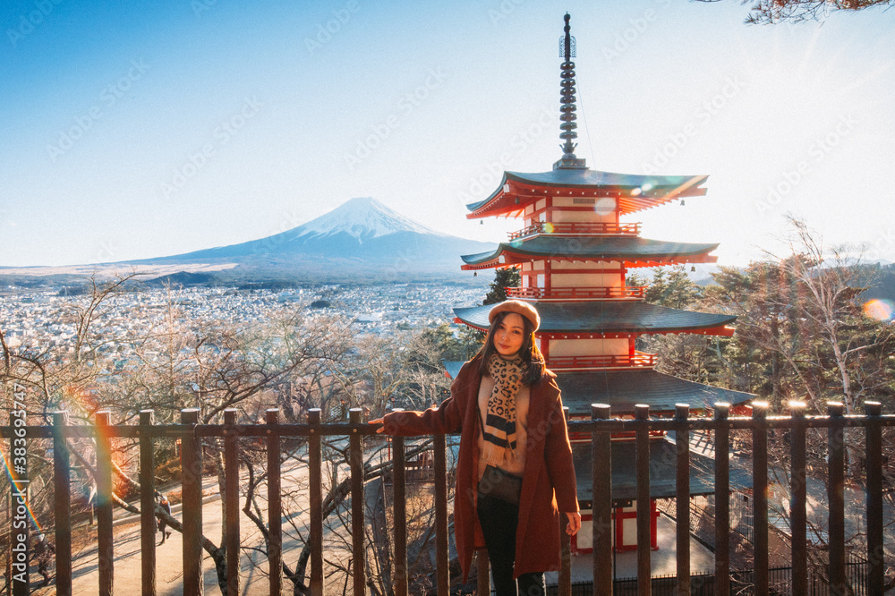 Pretty Girl standing Behind at Beautiful view of mountain Fuji and Chureito pagoda, Fujiyoshida, Japan. Backgound of Fuji Autumn leaves during sunset with clear blue sky.
