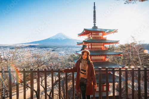 Obraz na płótnie Pretty Girl standing Behind at Beautiful view of mountain Fuji and Chureito pagoda, Fujiyoshida, Japan. Backgound of Fuji Autumn leaves during sunset with clear blue sky. w salonie