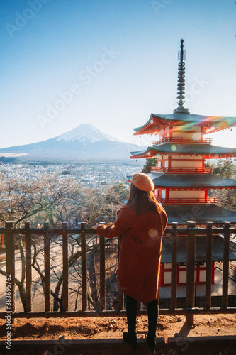 Pretty Girl standing Behind at Beautiful view of mountain Fuji and Chureito pagoda, Fujiyoshida, Japan. Backgound of Fuji Autumn leaves during sunset with clear blue sky.