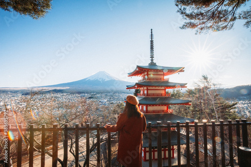 Obraz na płótnie Pretty Girl standing Behind at Beautiful view of mountain Fuji and Chureito pagoda, Fujiyoshida, Japan. Backgound of Fuji Autumn leaves during sunset with clear blue sky. w salonie