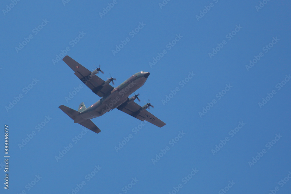 hercules plane flying high in the bright blue sky hercules plane flying high in the bright blue sky