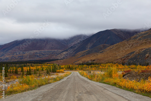 View of Scenic Road and Mountains on a Cloudy Fall Day in Canadian Nature. Taken near Tombstone Territorial Park, Yukon, Canada.