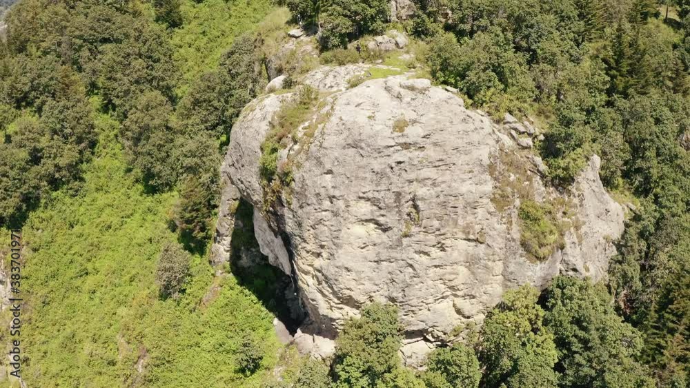 Aerial shot of the top of the mountain overlooking the city - aerial view of the cliff surrounded by forest - giant stone in the middle of the forest in Quetzaltenango Guatemala Aerial shot of the top of the mountain overlooking the city - aerial view of the cliff surrounded by forest - giant stone in the middle of the forest in Quetzaltenango Guatemala