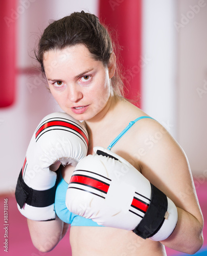 attentive sportwoman in the boxing hall practicing boxing punches during training