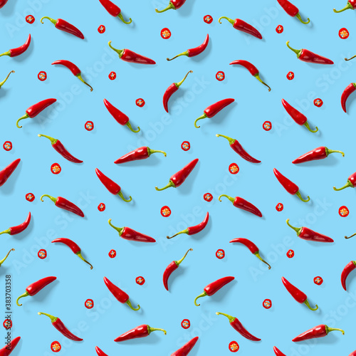 Seamless pattern made of red chili or chilli on blue background. Minimal food pattern. Red hot chilli seamless peppers pattern. Food background.