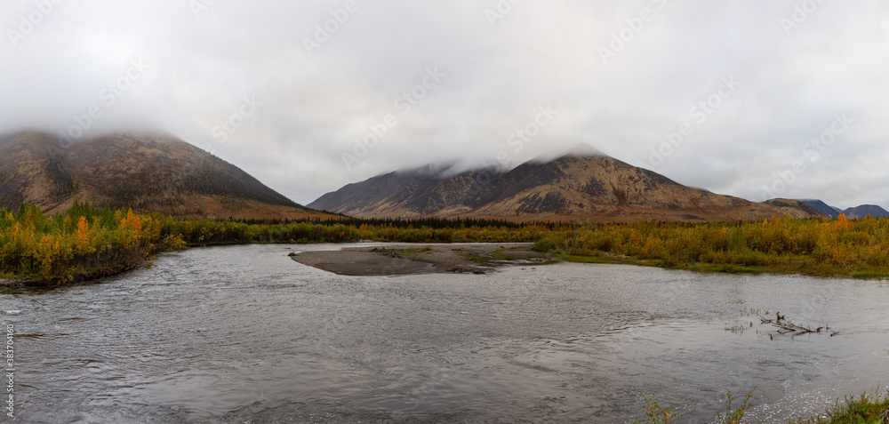 Panoramic View of Scenic River and Mountains on a Fall Day in Canadian Nature. Taken near Tombstone Territorial Park, Yukon, Canada.