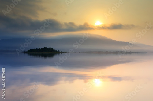 Light morning with fog on the lake at sunrise