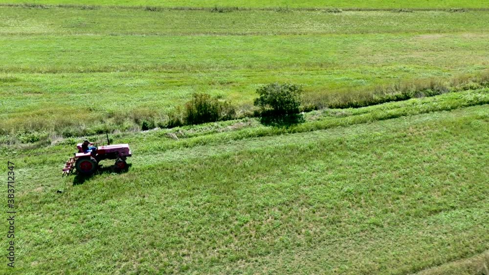 Croatia - Industrial Farming Tractor Plowing Grass Field, Aerial Overhead Drone View Croatia - Industrial Farming Tractor Plowing Grass Field, Aerial Overhead Drone View