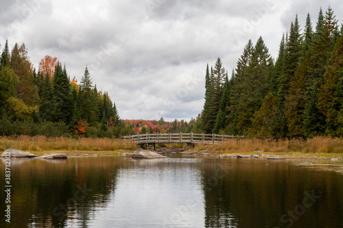 View of a peaceful lake with a wooden bridge in the Frontenac national park, Canada