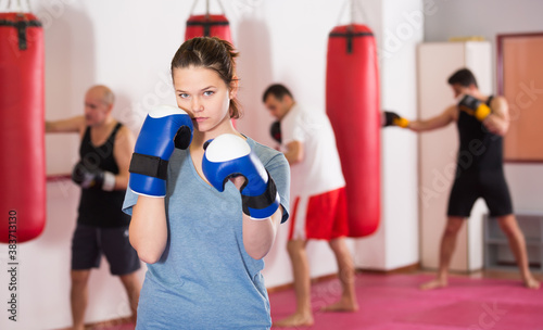 Positive sportwoman in the boxing hall practicing boxing punches © JackF