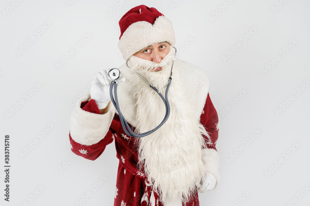 Santa Claus holds a stethoscope in his hand. Isolated on white Santa Claus holds a stethoscope in his hand. Isolated on white