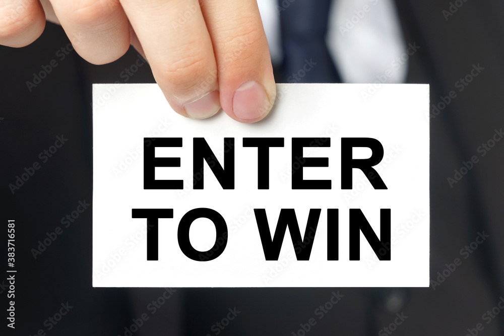 Businessman shows a card with the text ENTER TO WIN Businessman shows a card with the text ENTER TO WIN