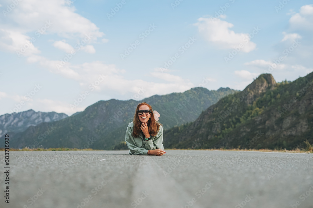 Beautiful smiling young woman traveler in casual clothes on road, trip to mountains