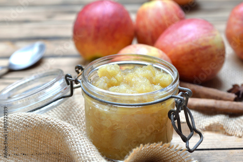 close on homemade compote in a glass jar with red apples background