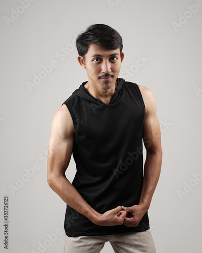 Young men in empty black tanktop, stylish and posing like famous T-shirt models. Men's t-shirt template and mockup design for print. photo shoot models isolated white background. © AndhikaRaya