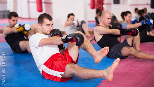 Ordinary sportsmen practicing boxing punches in the boxing hall