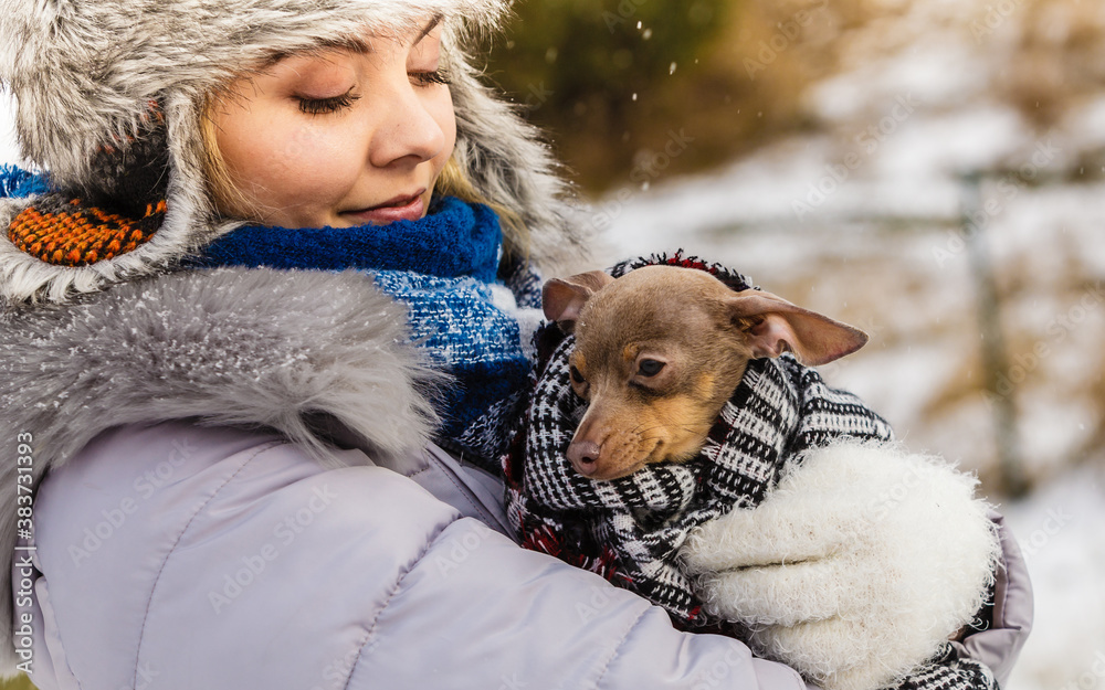 Woman hug warming her little dog in winter Woman hug warming her little dog in winter