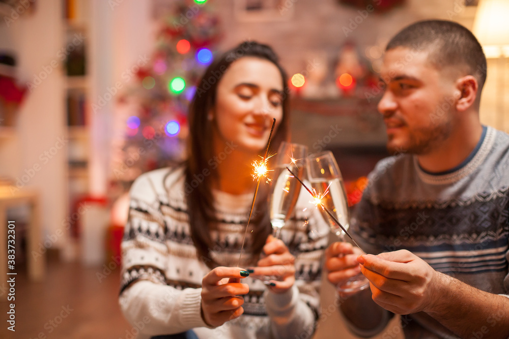 Loving couple holding hand fireworks on christmas day.