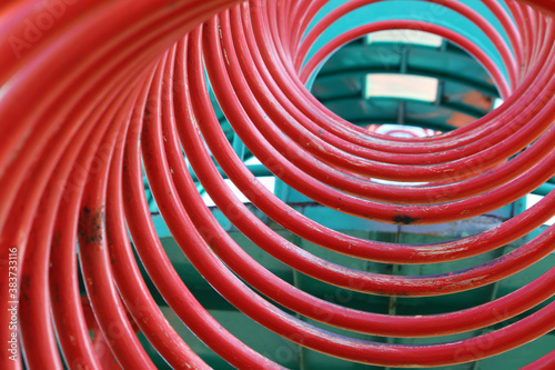 Fototapeta Naklejka Na Ścianę i Meble -  赤い螺旋状の公園遊具の中を覗いた様子
