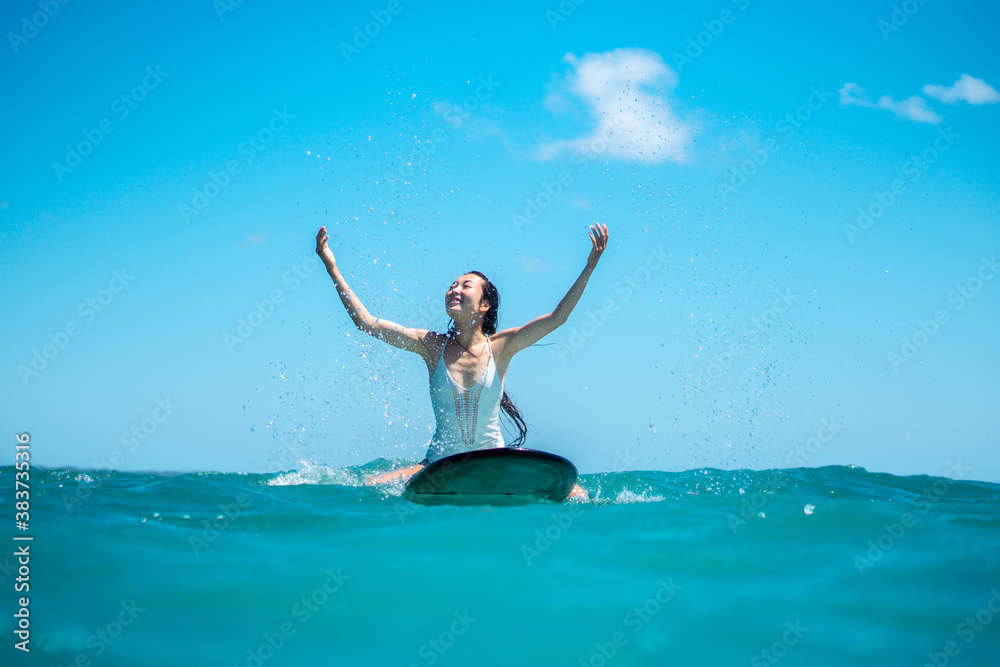 Portrait of surfer girl on surf board in blue ocean Portrait of surfer girl on surf board in blue ocean