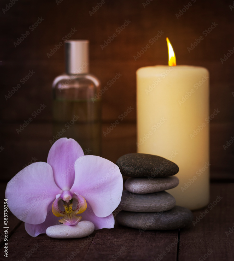 The concept of Zen and relaxation.Spa still life with a burning candle on a wooden background The concept of Zen and relaxation.Spa still life with a burning candle on a wooden background