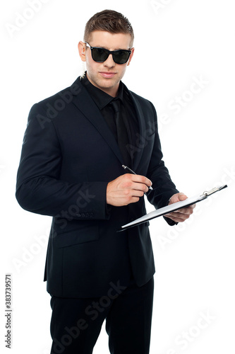 Security officer writing on clipboard photo