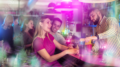 Cheerful girl with best friends partying in bar  dancing and toasting drinks. High quality photo
