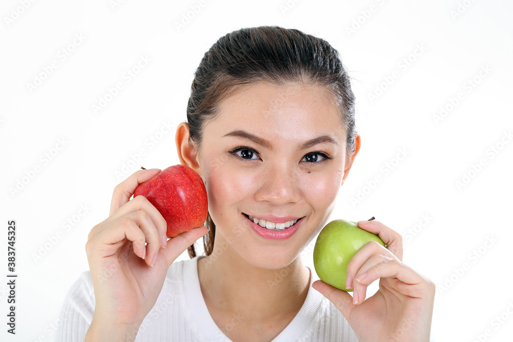 beautiful young south east Asian Chinese woman holding healthy green and red apple on cheek on white background beautiful young south east Asian Chinese woman holding healthy green and red apple on cheek on white background