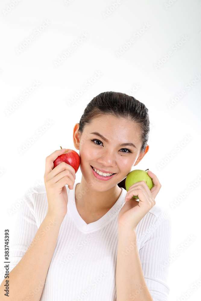 beautiful young south east Asian Chinese woman holding healthy green and red apple on cheek on white background beautiful young south east Asian Chinese woman holding healthy green and red apple on cheek on white background