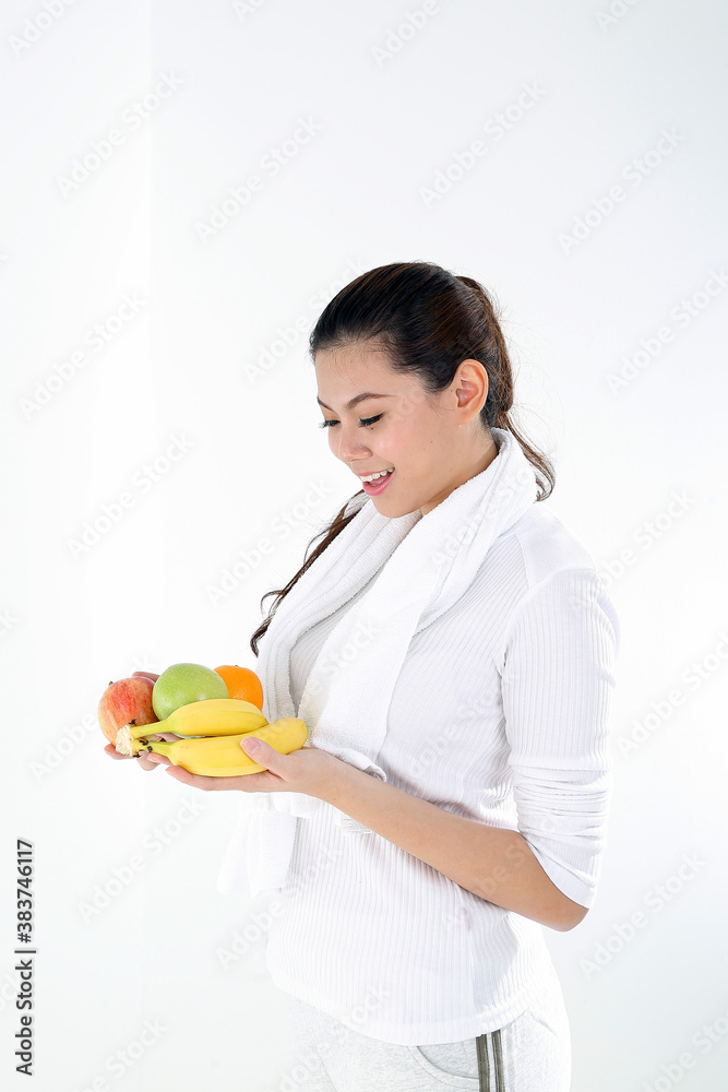 Beautiful young south east Asian Chinese healthy workout exercise look at apple banana orange fruit on hand on white background Beautiful young south east Asian Chinese healthy workout exercise look at apple banana orange fruit on hand on white background