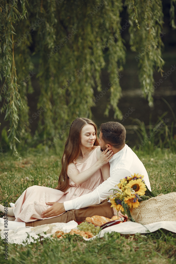 Couple in a field. Brunette in a white dress. Pair sitting on a grass. Couple in a field. Brunette in a white dress. Pair sitting on a grass.