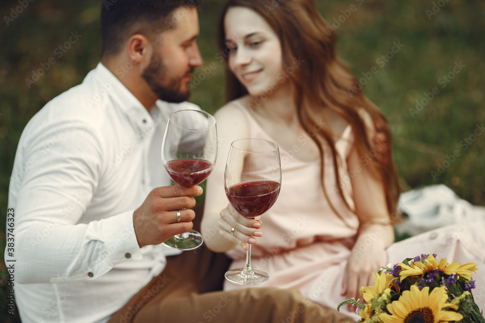Couple in a field. Brunette in a white dress. Pair sitting on a grass. Couple in a field. Brunette in a white dress. Pair sitting on a grass.