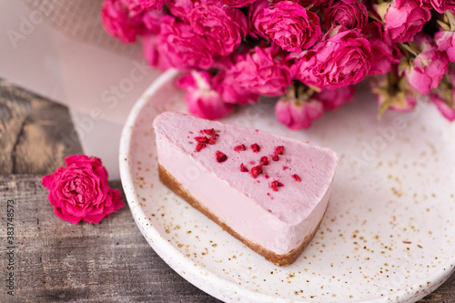 Milk cheesecake on a plate with a beautiful decoration and a bouquet of flowers