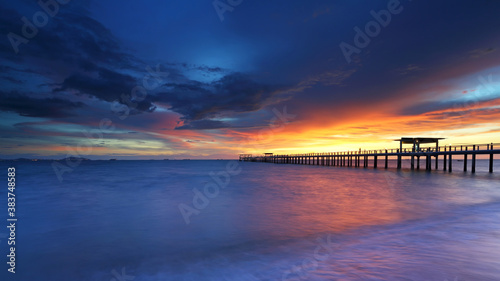 Perspective of wood bridge with sunset in sea water at Bangsaen Beach. Chonburi of Thailand